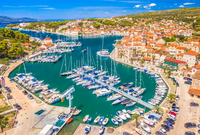 Aerial of Milna marina and a stone village with a church tower, Brač island, Croatia