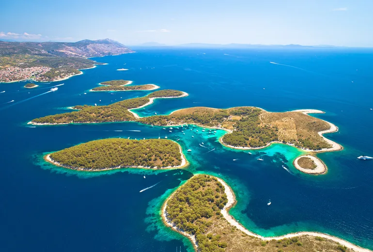 Aerial of the Pakleni Islands turquoise channels dotted with moored yachts near Hvar