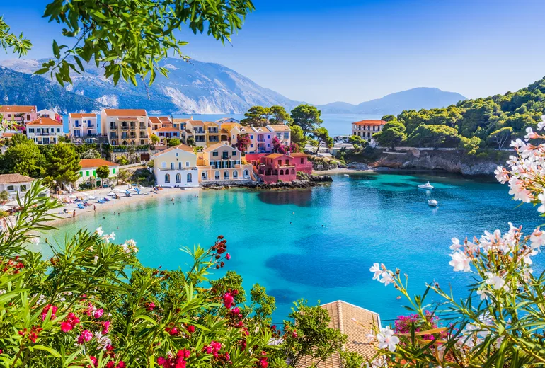 Colourful Assos village around a turquoise bay framed by flowers, Kefalonia, Greece