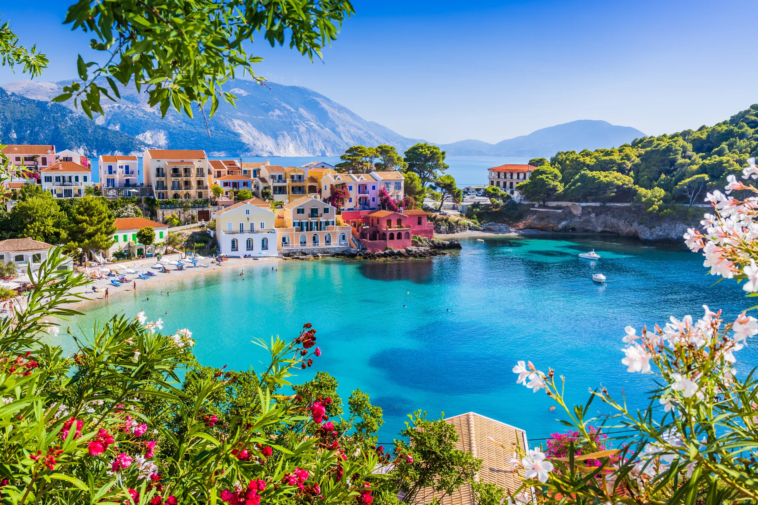 Colourful Assos village around turquoise bay framed by flowers, Kefalonia