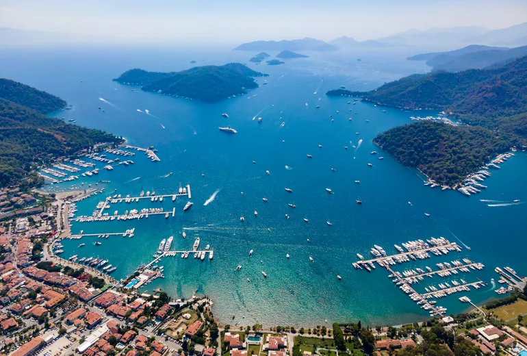 Sweeping aerial of Gocek bay, marinas full of yachts, town and pine islands in Turkiye