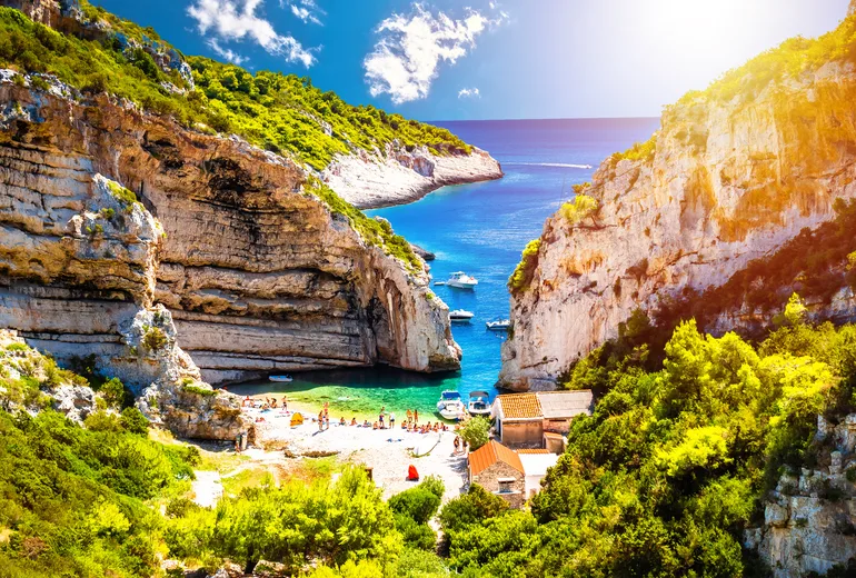 Swimmers in the sheltered Stiniva cove on Vis island