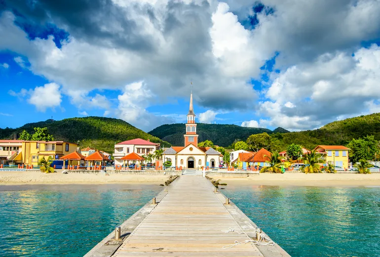 Wooden pier leading to a seaside church in Anses-d'Arlet village, Martinique